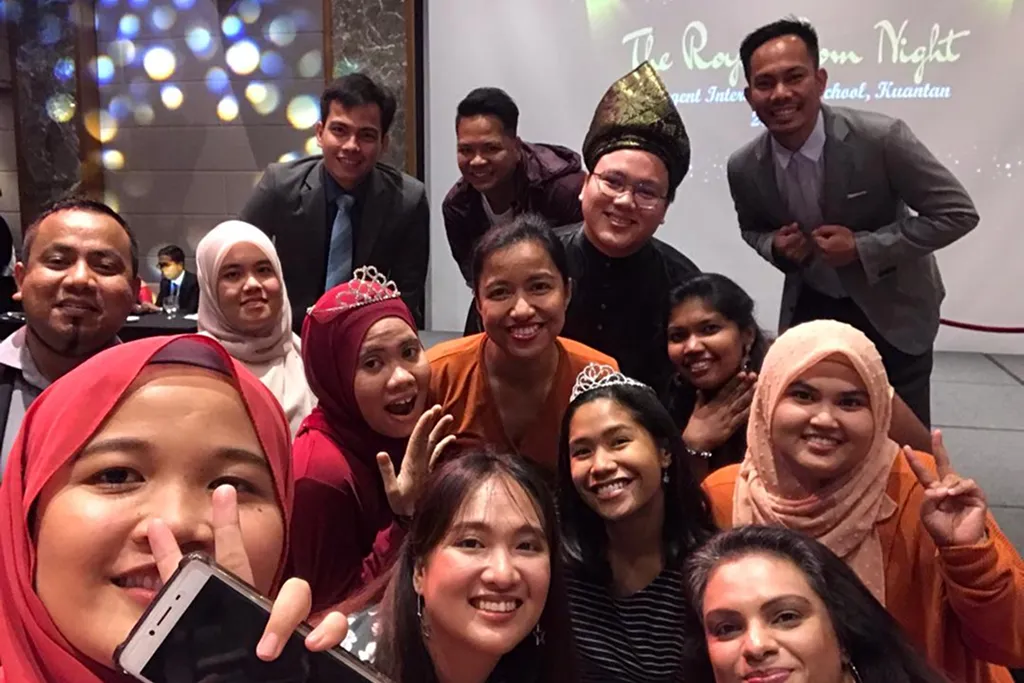 Regent International School teachers and staff take a happy group selfie during a cultural celebration at the school.